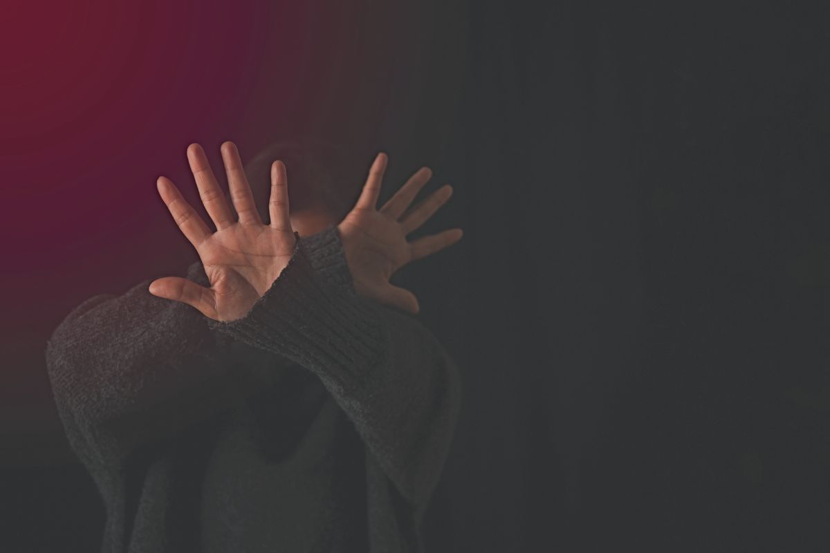 Person raising hands to protect themselves. Person raising hands to protect themselves.