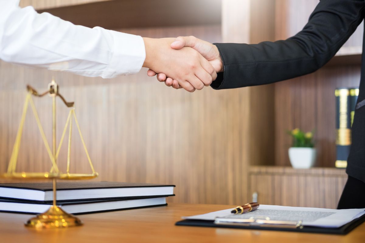 Client and lawyer shaking hands in an office. Client and lawyer shaking hands in an office.