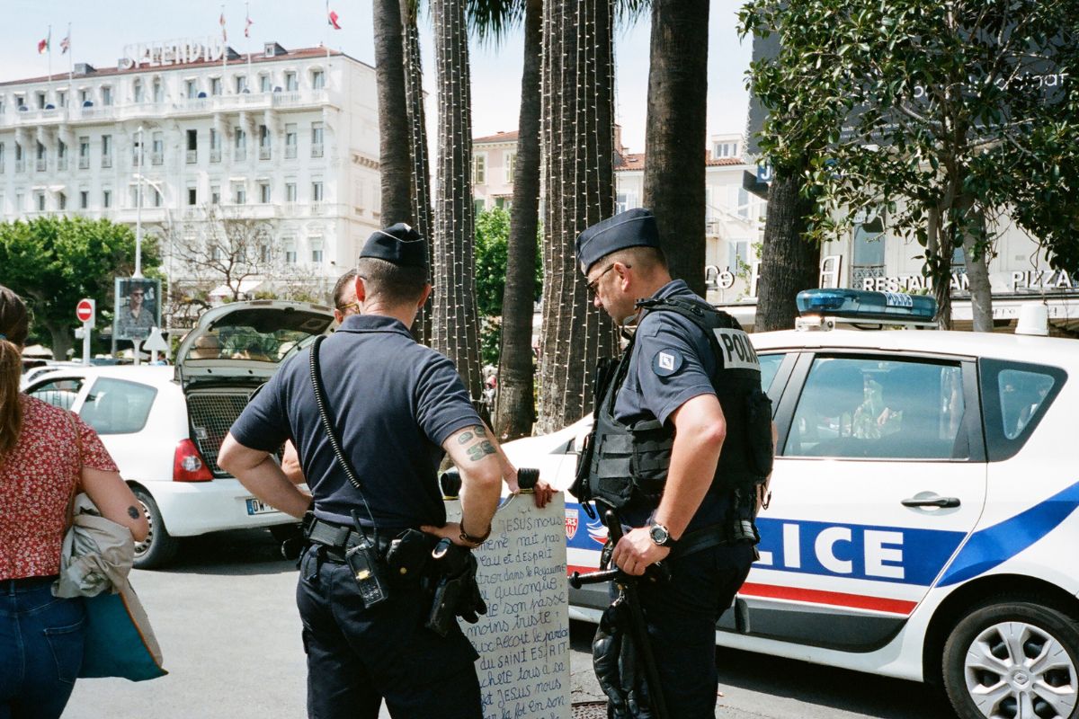 Two peace officers standing beside a patrol car. Two peace officers standing beside a patrol car.