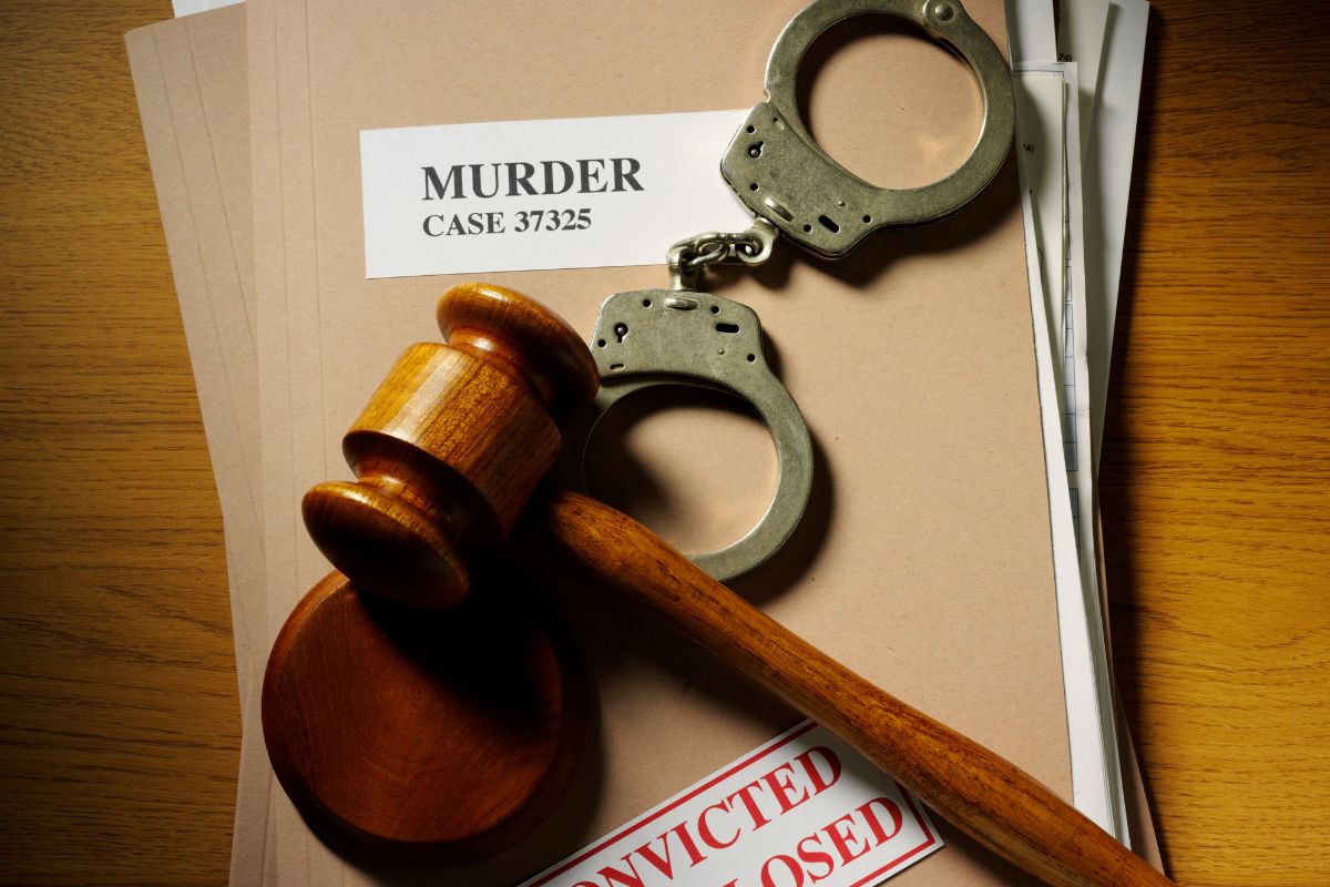 Gavel and handcuffs on a murder case file. Gavel and handcuffs on a murder case file.