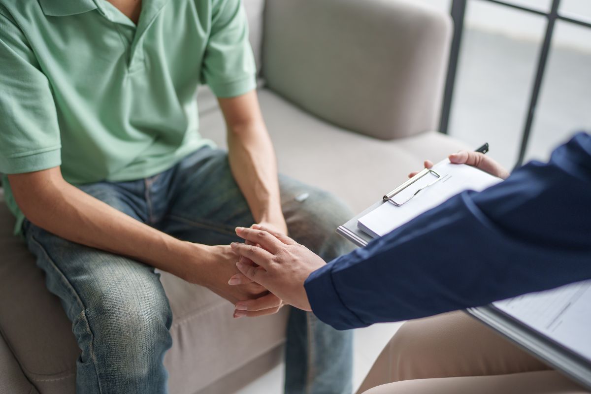 Man receiving support during a mental health consultation. Man receiving support during a mental health consultation.