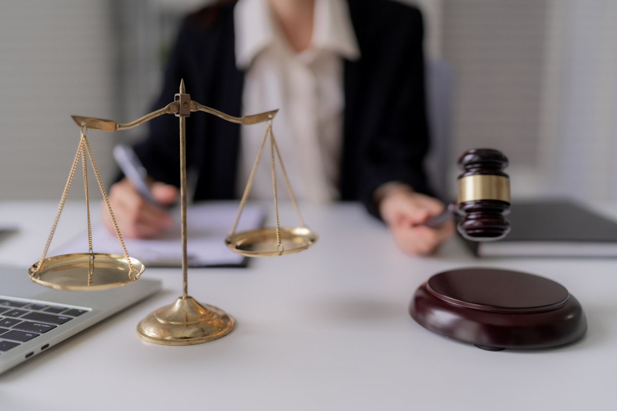 Scales of justice and a judge’s gavel on a desk in a law office. Scales of justice and a judge’s gavel on a desk in a law office.