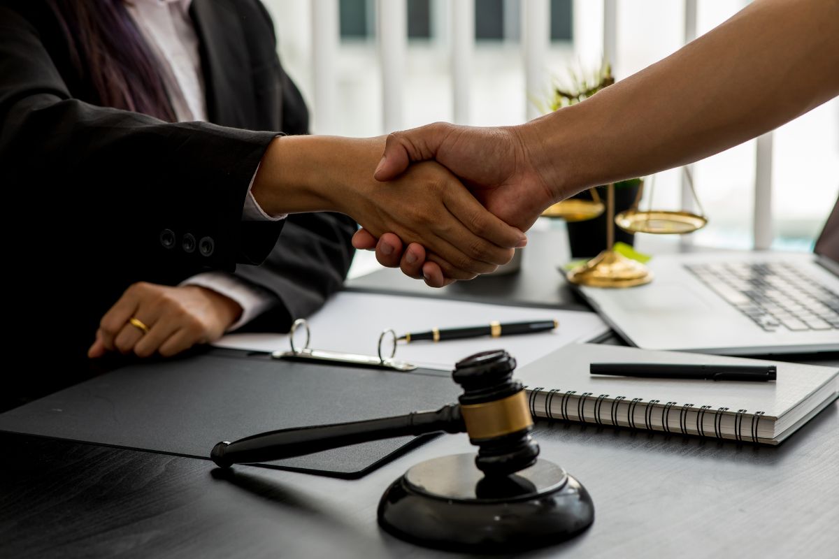 Client and lawyer shaking hands in an office. Client and lawyer shaking hands in an office.