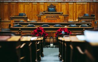 Empty courtroom with judge’s bench, witness stand and seating for legal trial.