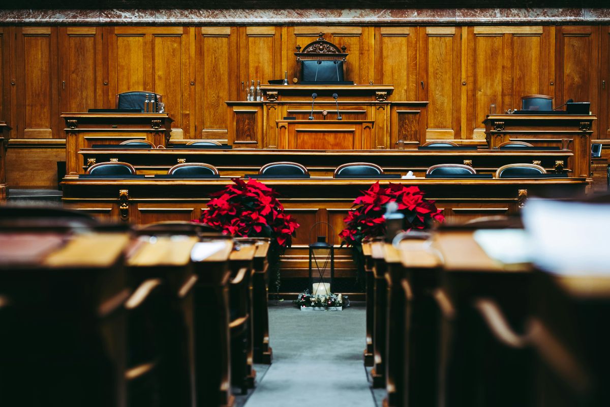 Empty courtroom with judge’s bench, witness stand and seating for legal trial.