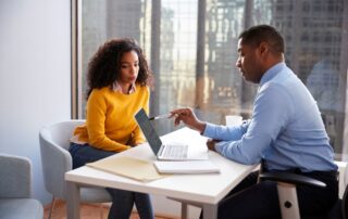 Female client meeting lawyer to discuss case and review documents.