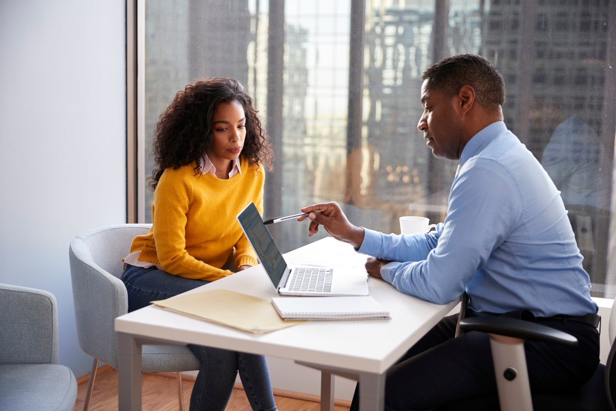 Female client meeting lawyer to discuss case and review documents.