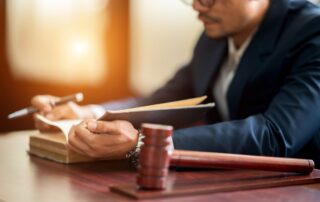 Lawyer reviewing documents at a desk with a gavel.