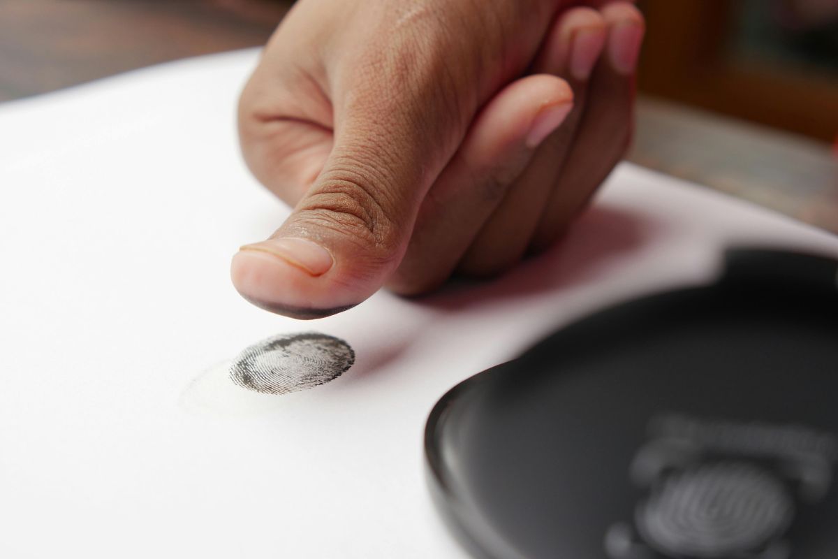 Close-up of a thumb making a fingerprint on paper. Close-up of a thumb making a fingerprint on paper.