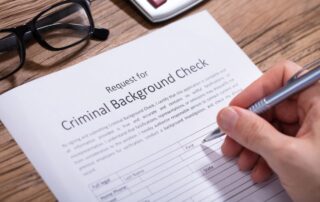 A man is filling out a criminal background check form.