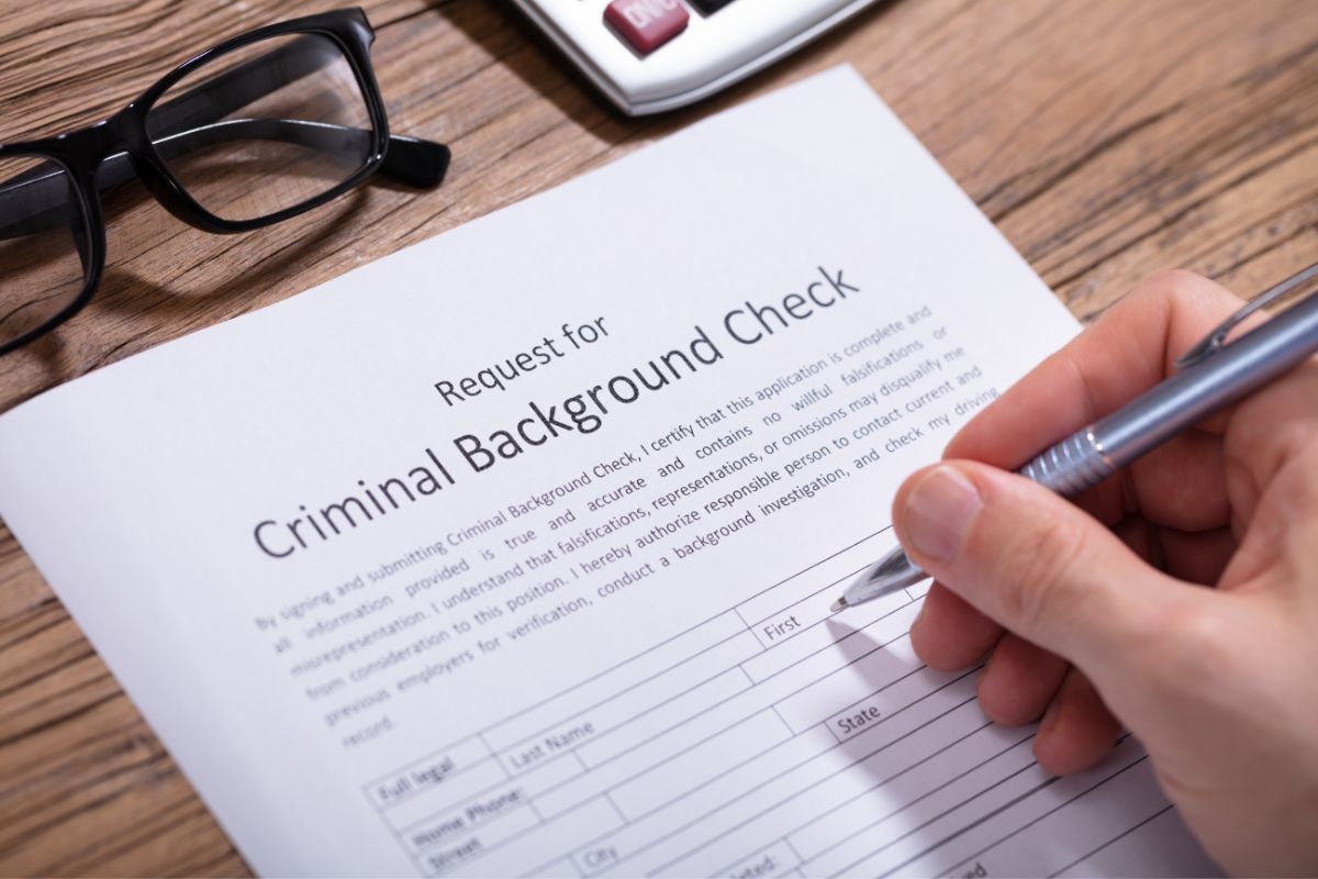 A man is filling out a criminal background check form.
