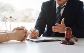 Justice lawyer meeting with client and gavel in courtroom.