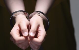 A man’s hands in handcuffs.