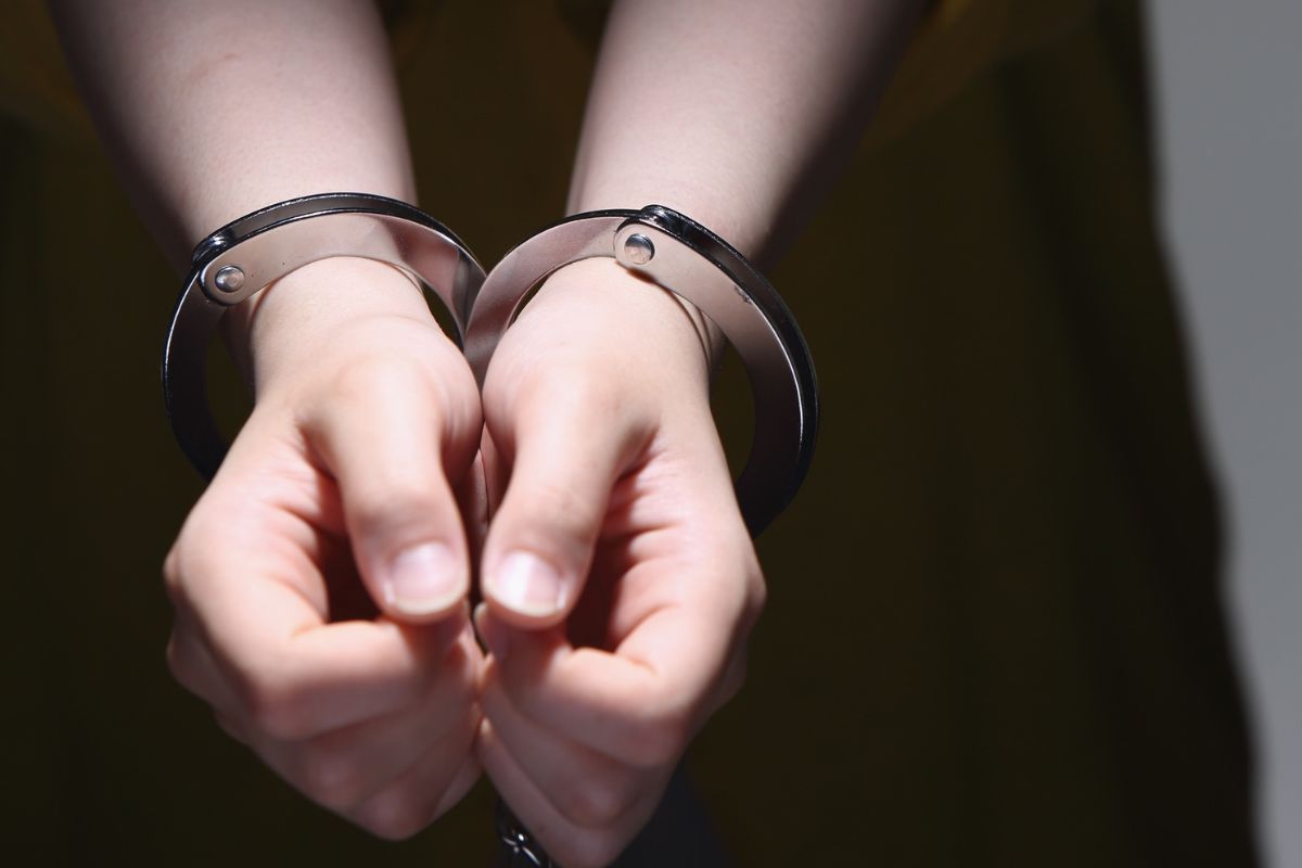 A man’s hands in handcuffs.