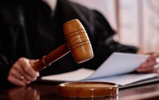 Judge holding a gavel in court.