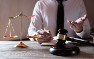 Lawyer sitting at a desk with a gavel and scales of justice.