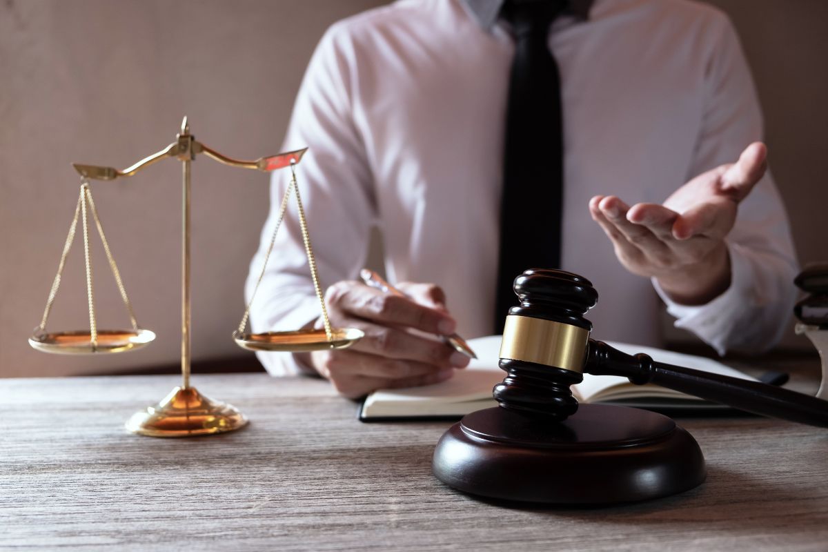Lawyer sitting at a desk with a gavel and scales of justice.