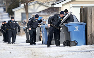 police warrant officers searching through bins