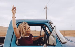 A woman smiling while driving.