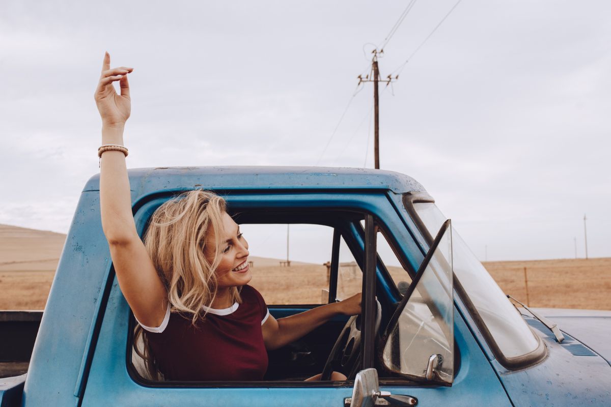A woman smiling while driving.