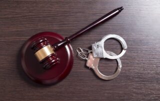 A judge’s gavel and a pair of handcuffs.