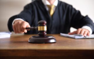 A judge holding a gavel in a courtroom.