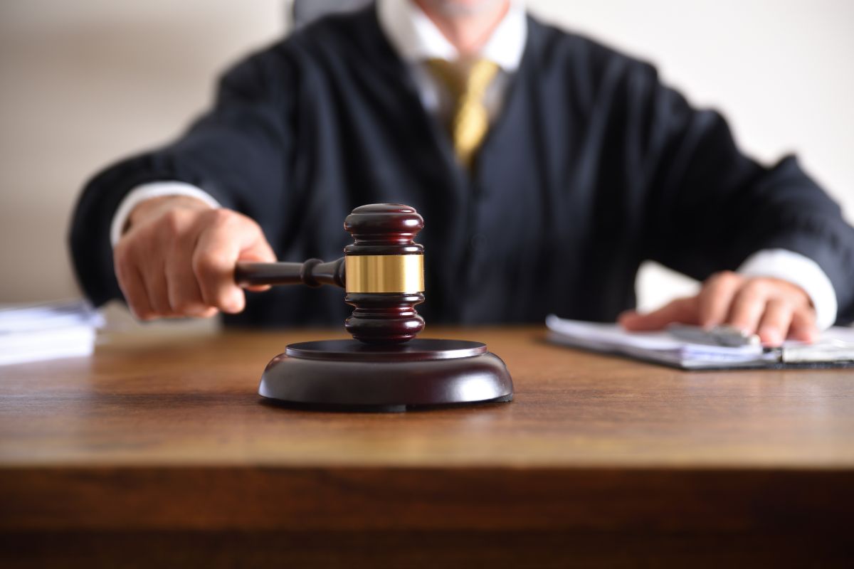 A judge holding a gavel in a courtroom.