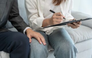 A man's hand rests inappropriately on a woman's leg.