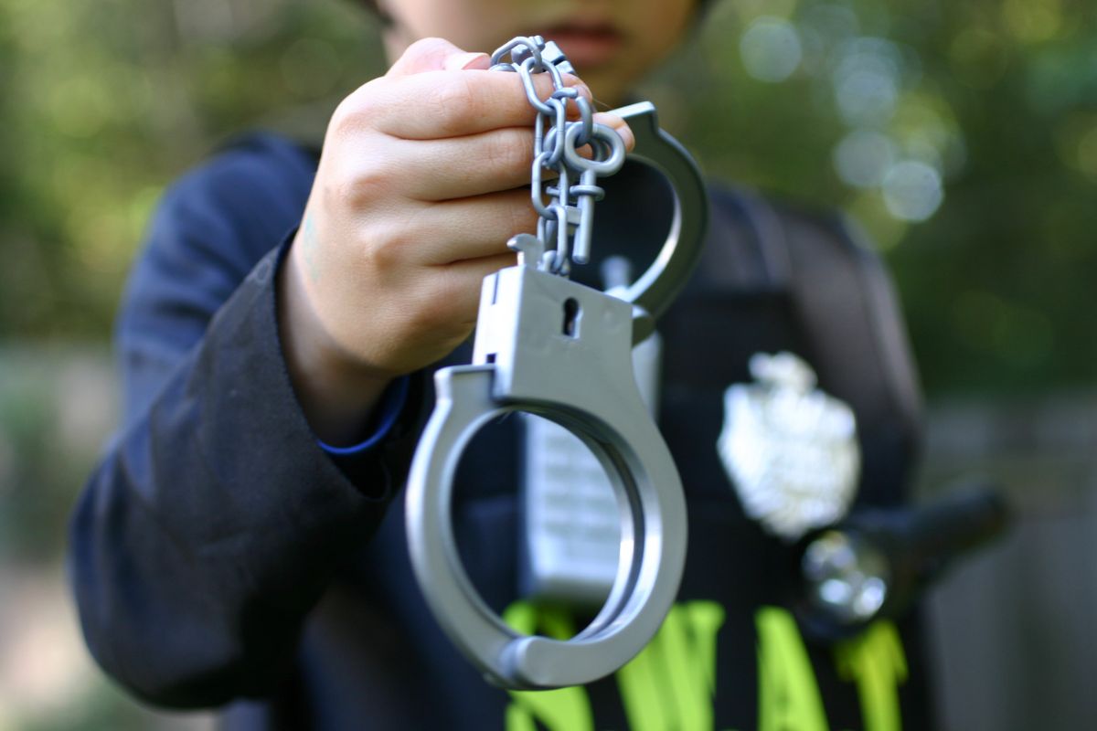 A law enforcement officer holding a pair of handcuffs.