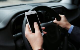 A man is driving while using his phone.