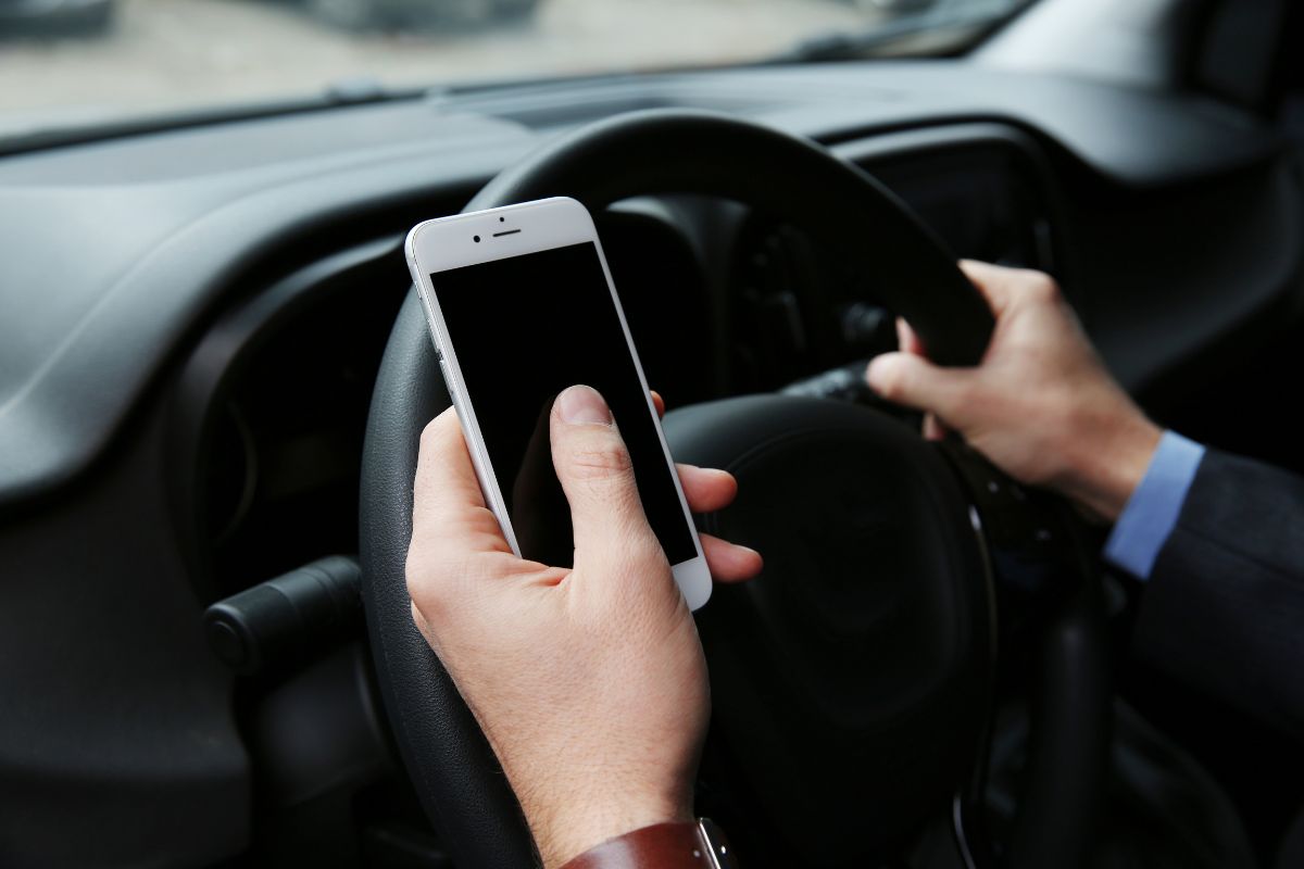 A man is driving while using his phone.