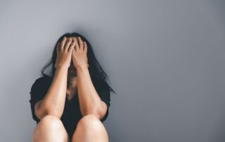 A distressed woman covering her face.