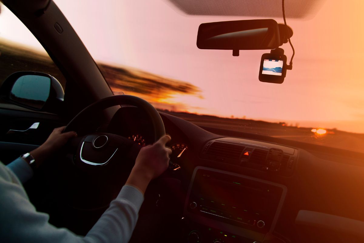 A man is driving at sunset.