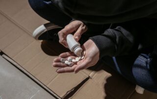 A man pouring white pills into their hand.