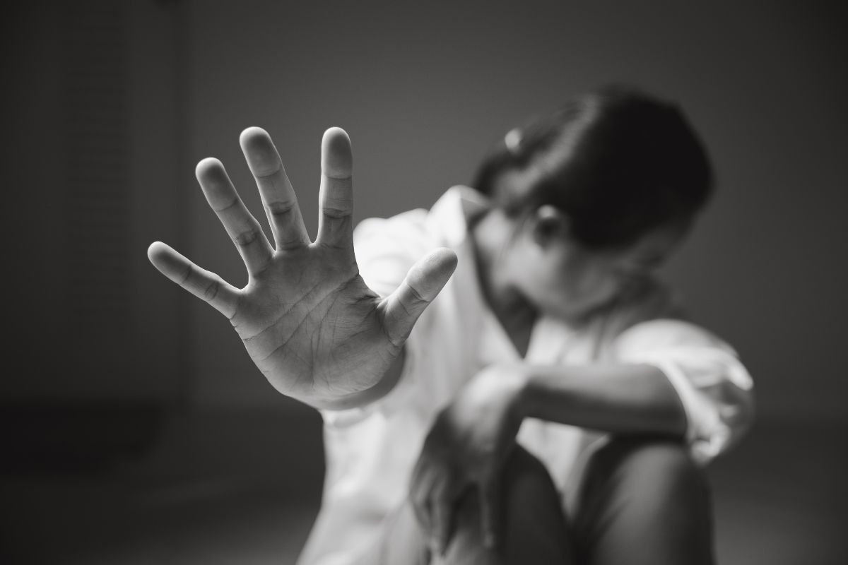 A woman raises her hand to stop.