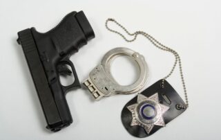 A handgun, handcuffs, and a police badge.