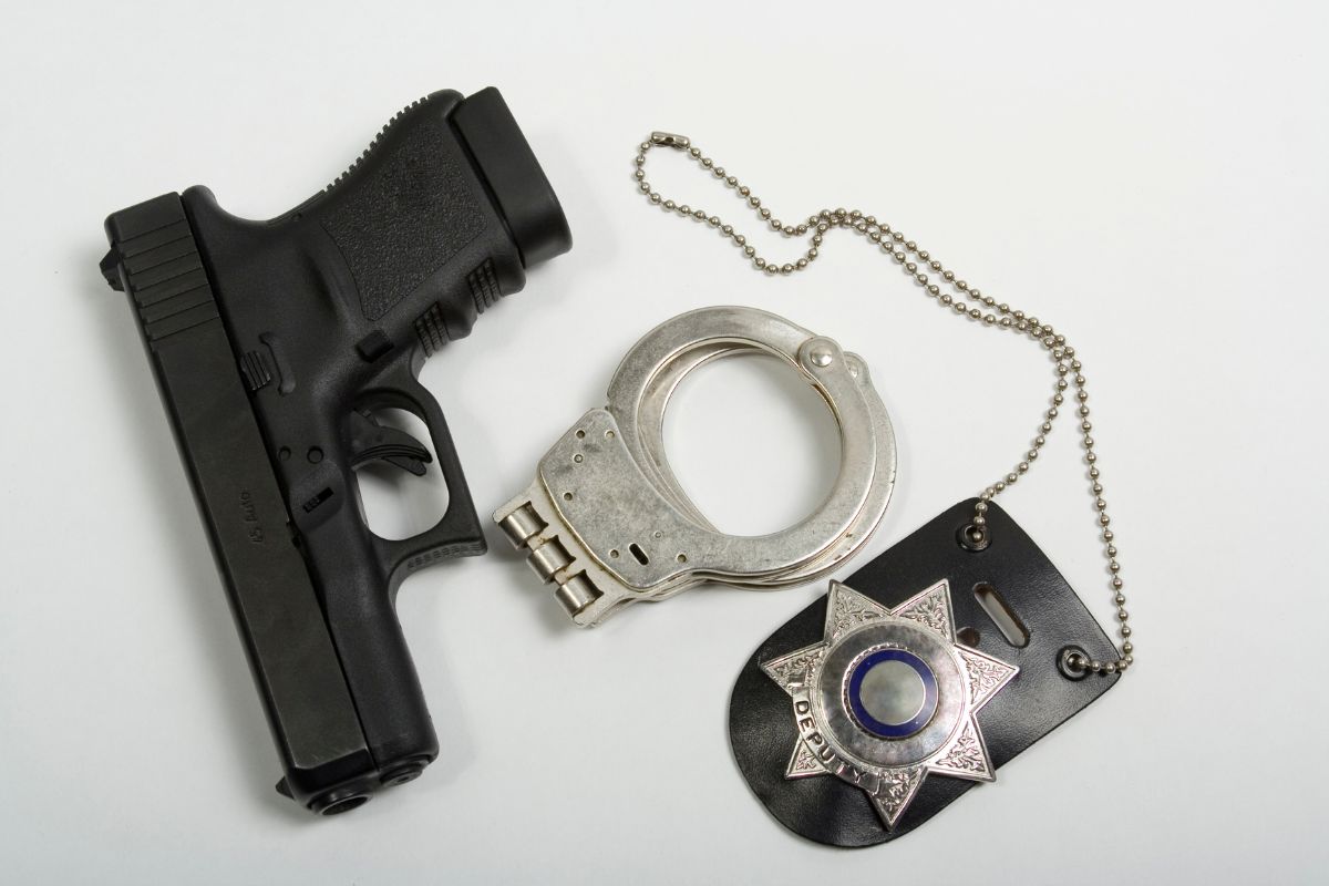 A handgun, handcuffs, and a police badge.