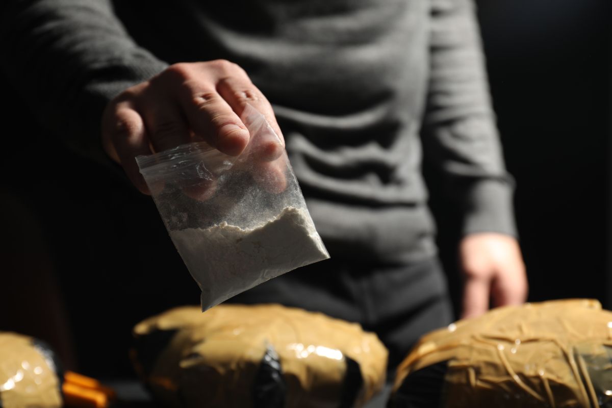 Man holding plastic bag with cocaine.