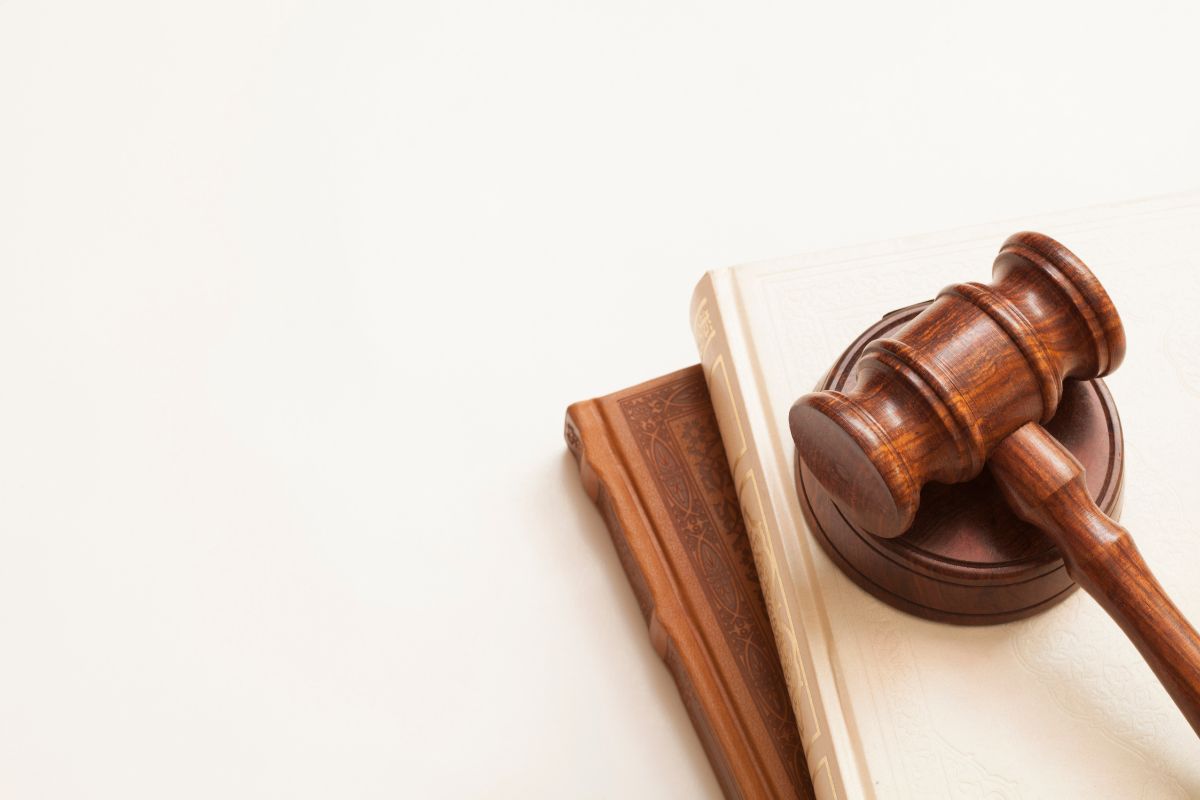 A judge’s wooden gavel resting on two law books.