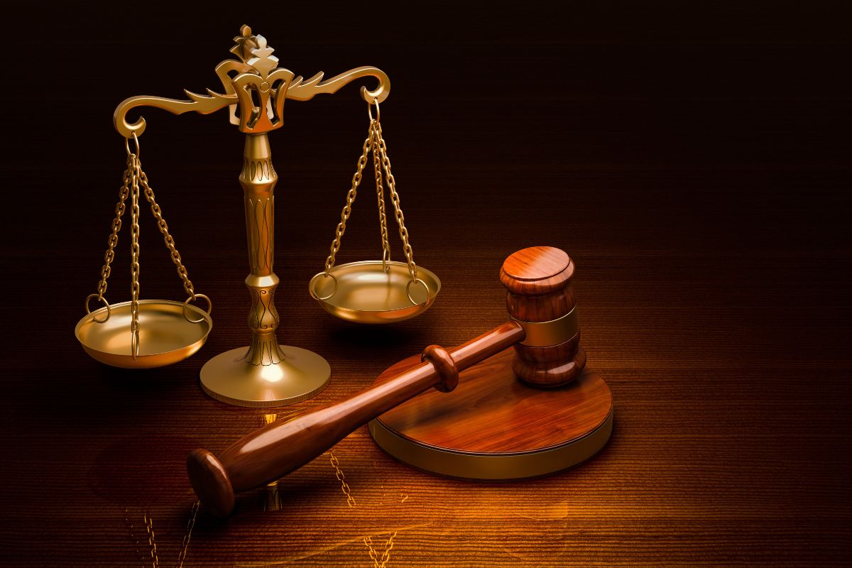 A wooden gavel and golden scales of justice.
