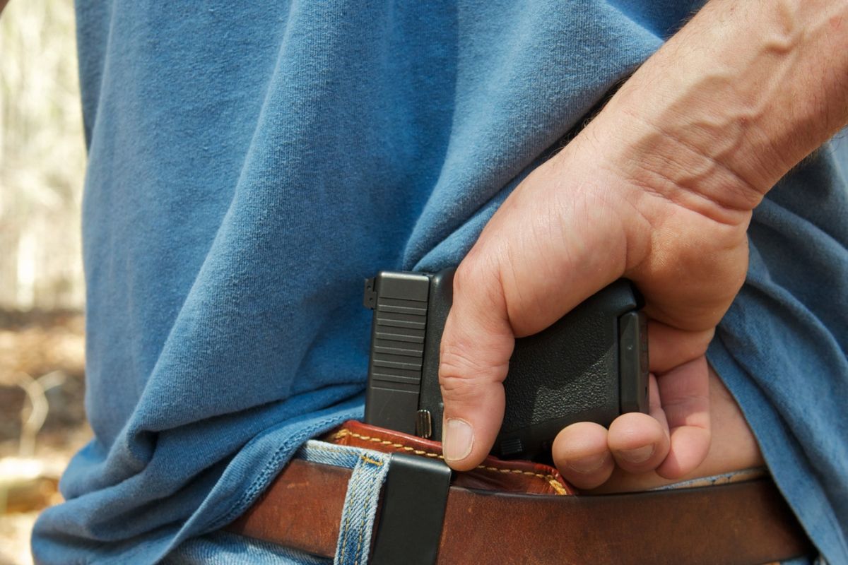 A man concealing a handgun.