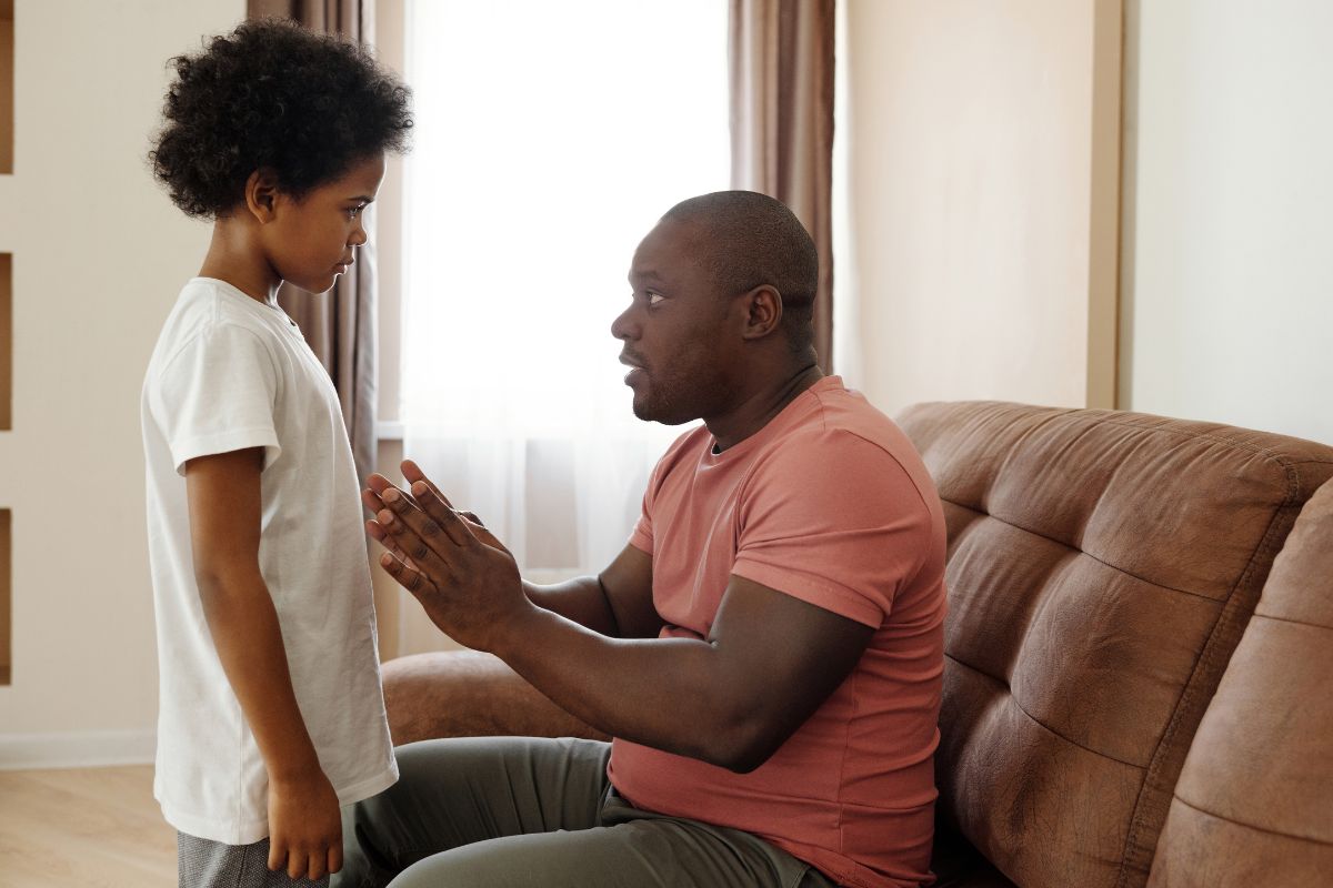 Father speaking seriously to his child in a home.