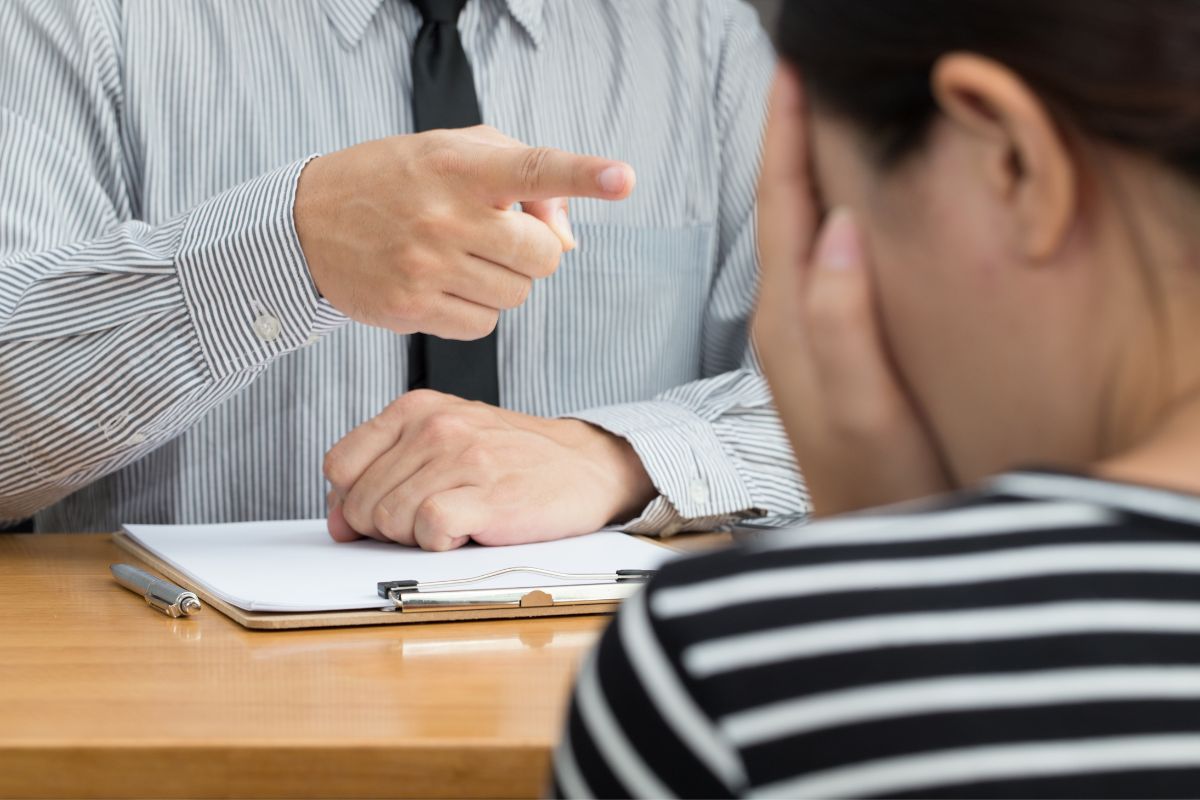 Man pointing aggressively at a distressed woman during a tense conversation.