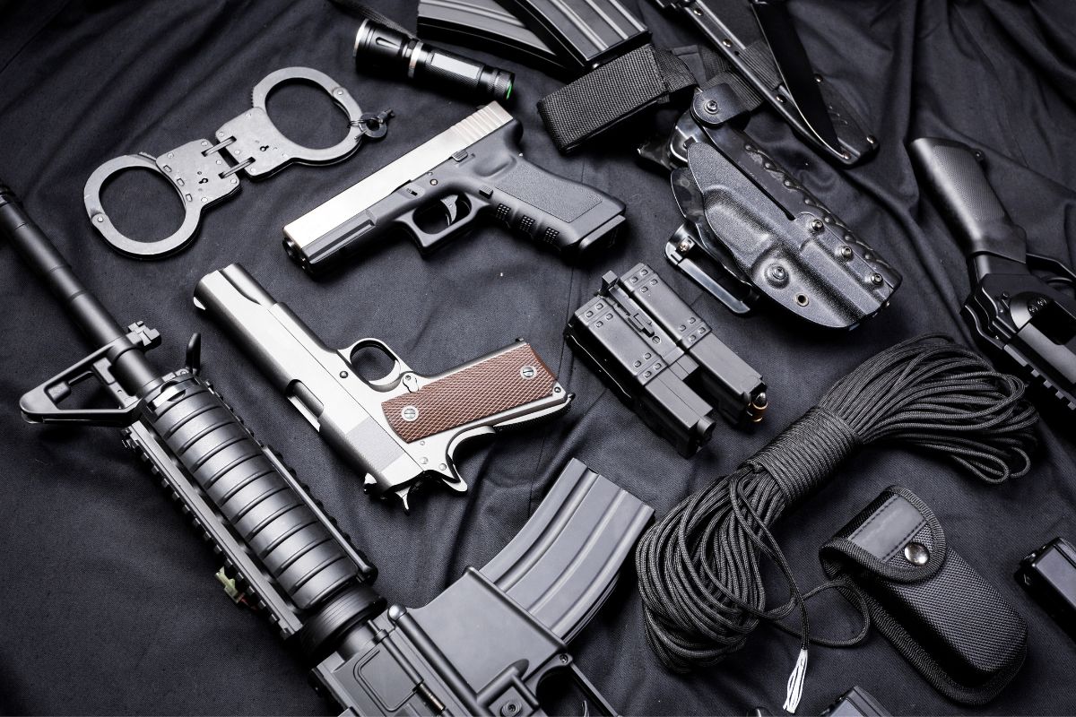 Collection of firearms, handcuffs, and tactical gear.