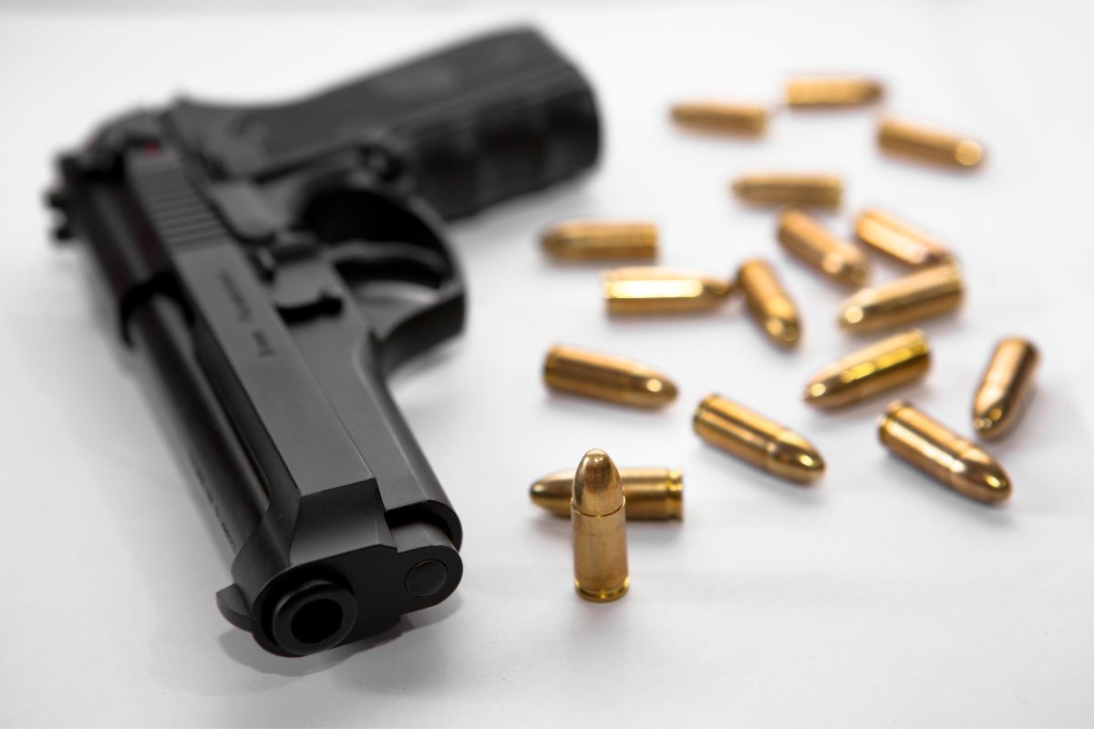 Handgun with scattered bullets around it.