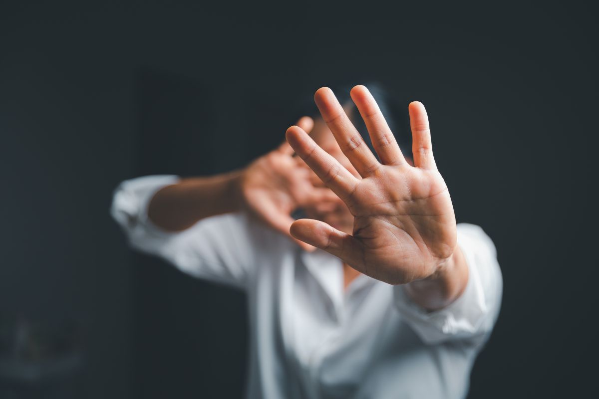 Female hand raised in fear.