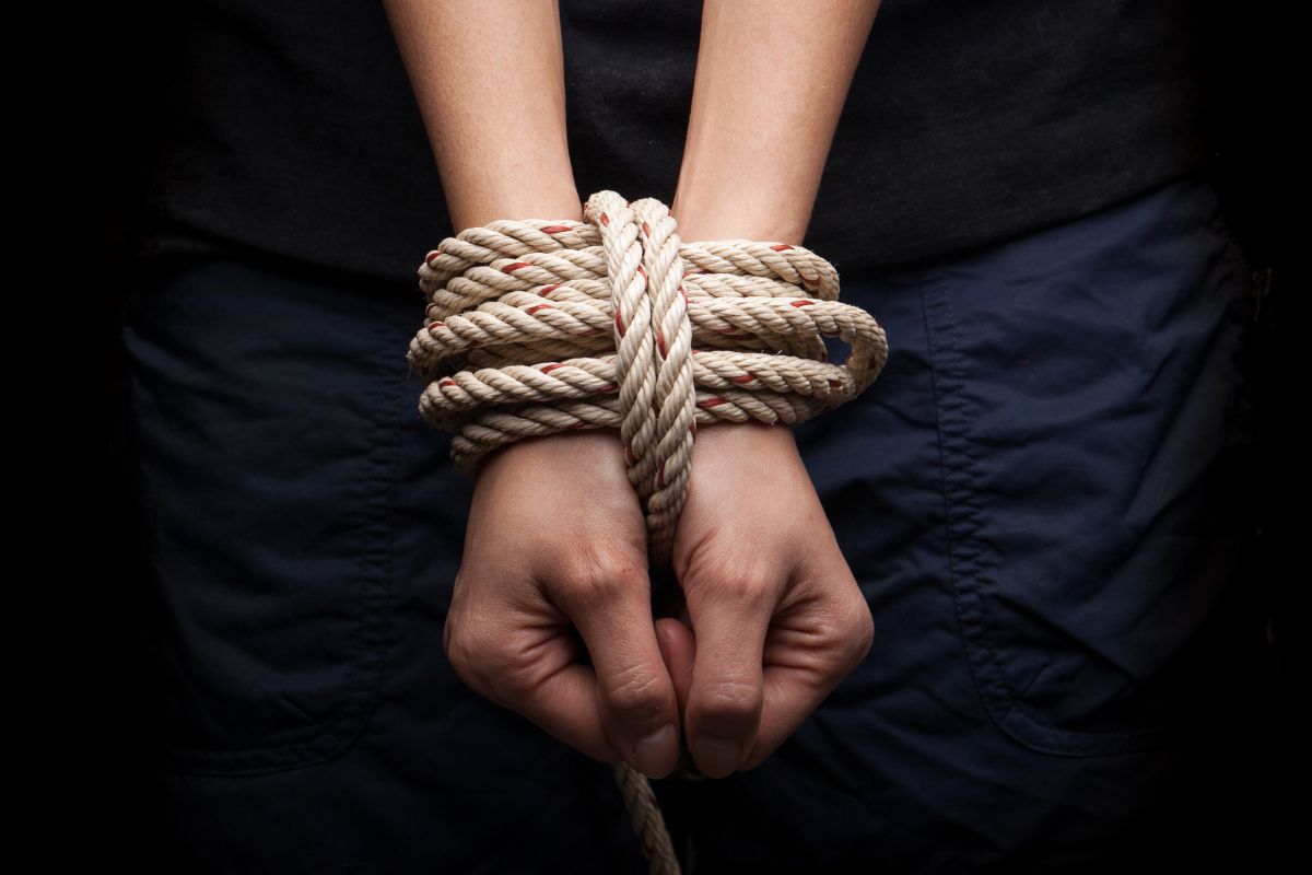 A person’s hands are tied tightly with a rope.