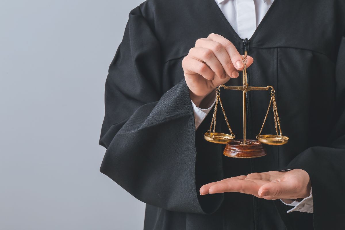 Judge holding justice scale symbolizing legal balance.