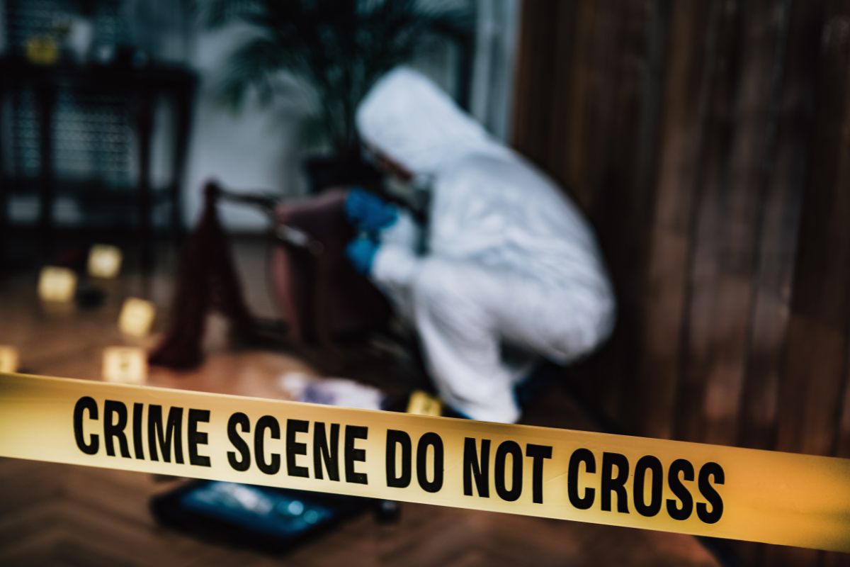 Crime scene and investigator examining evidence.