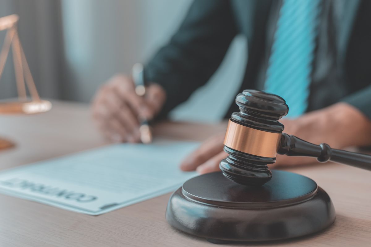 A lawyer signing legal documents at a desk.